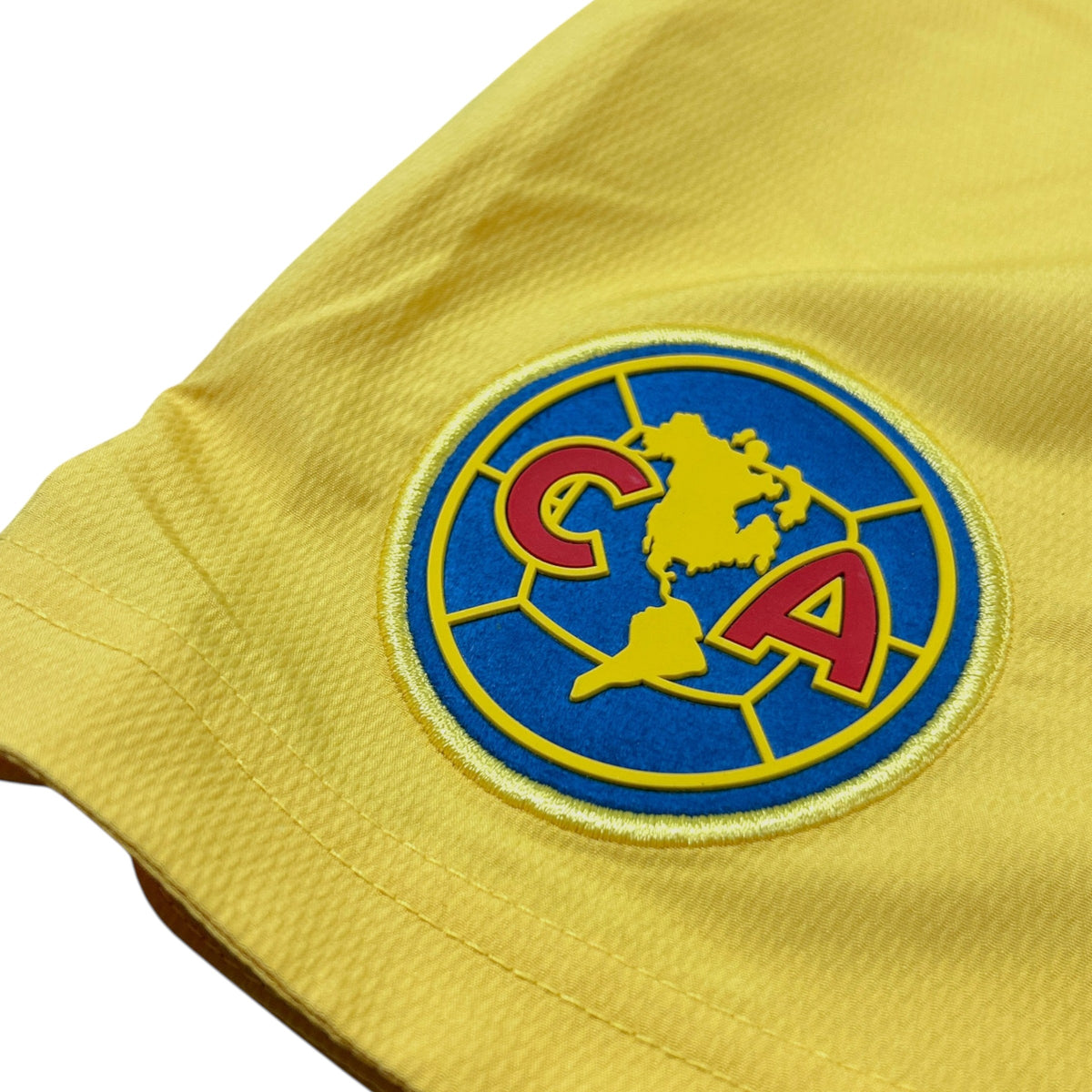ACOLDWASH yellow Nike Club América football shorts featuring an embroidered club crest with silicone detailing.