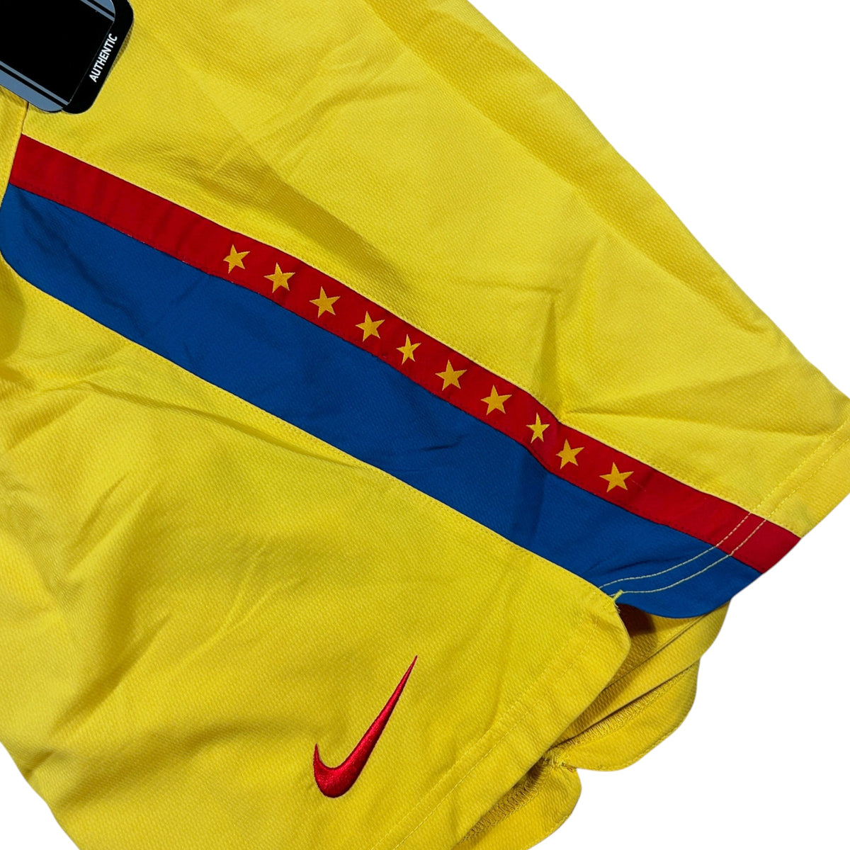 ACOLDWASH vintage 2005-06 Nike Club América football shorts in yellow with red and blue star-patterned side panels.