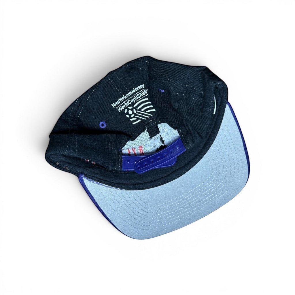 ACOLDWASH black snap cap with light blue brim, embroidered with "New York New Jersey World Cup USA 94" text and logo.